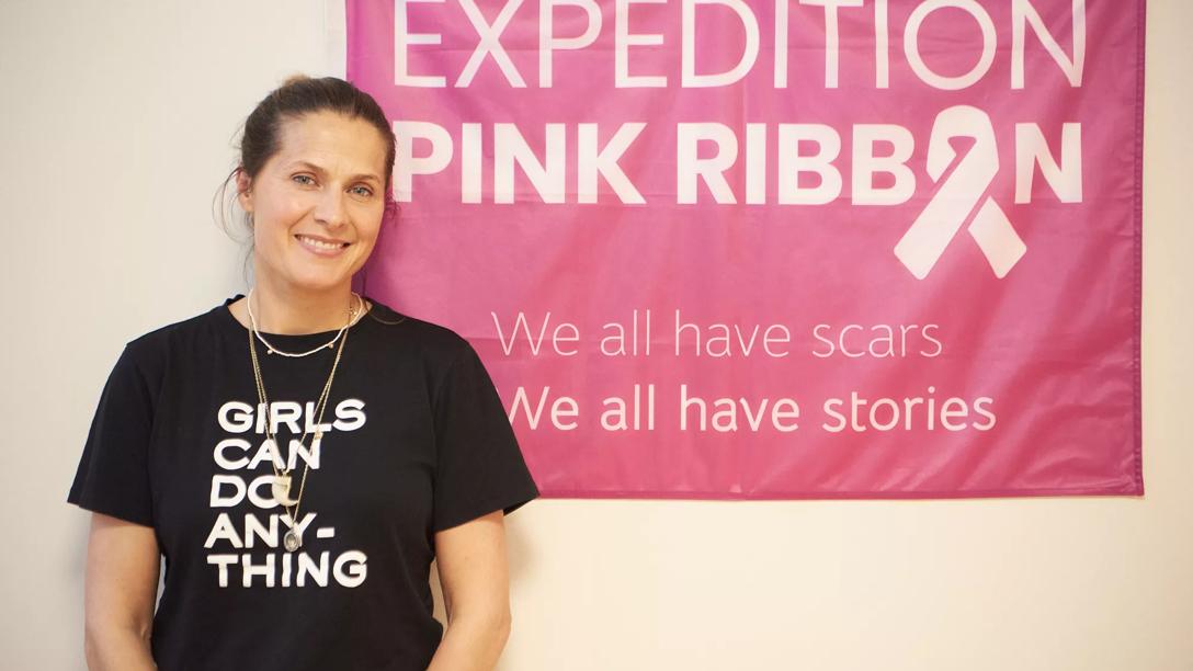 Andrea Rudolph foran et Pink Ribbon Expedition banner 