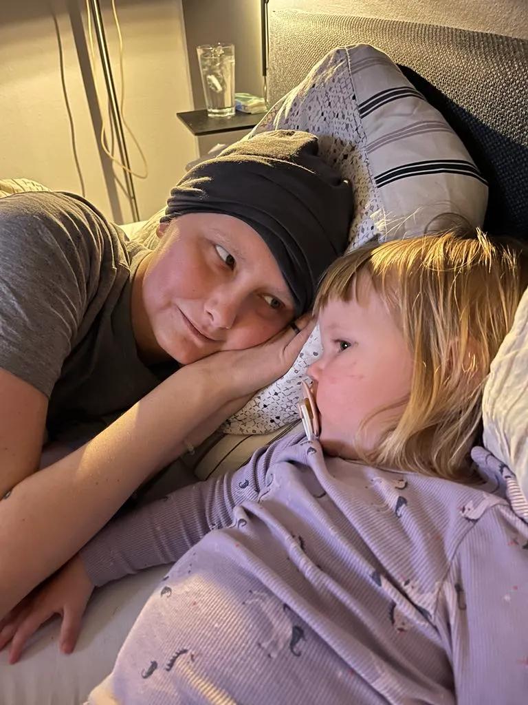 Julie og Freja ligger i sengen sammen. 