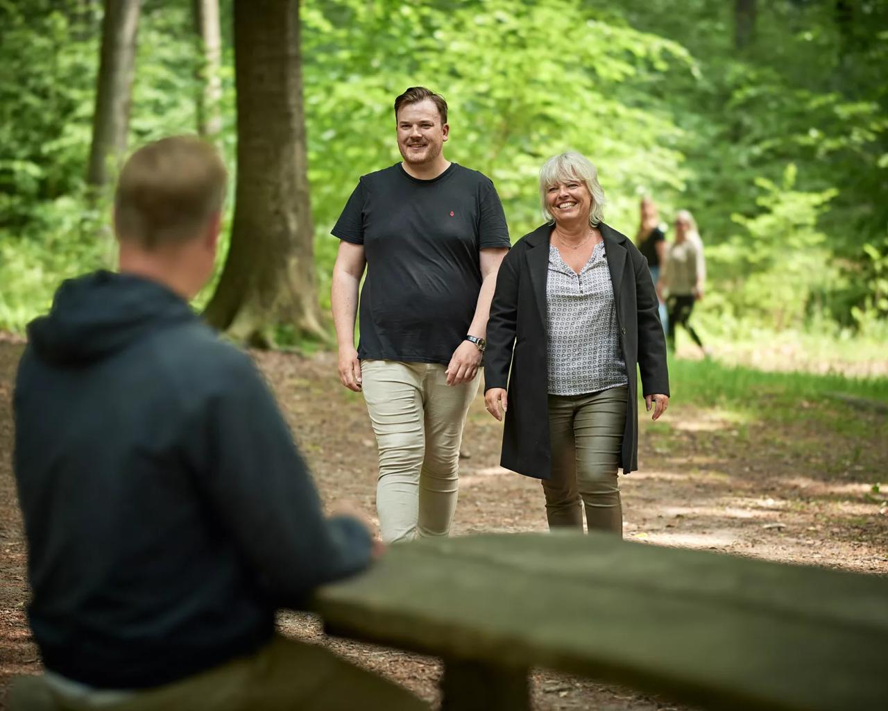 To personer med overvægt går en tur i skoven
