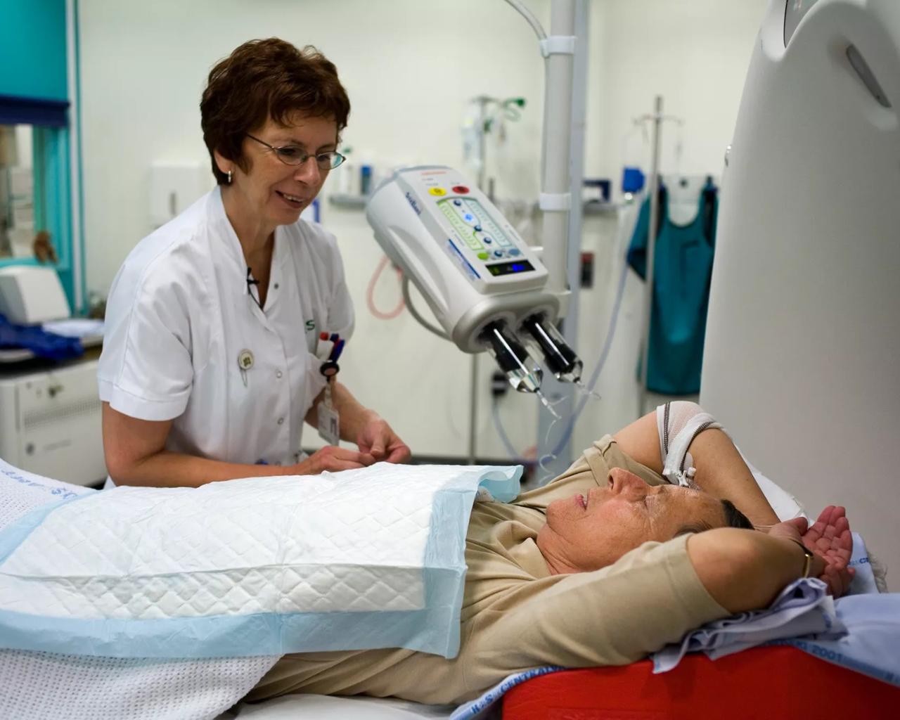 Kvindelig læge hjælper en kvindelig patient med at ligge rigtigt i en pet-ct-scanner