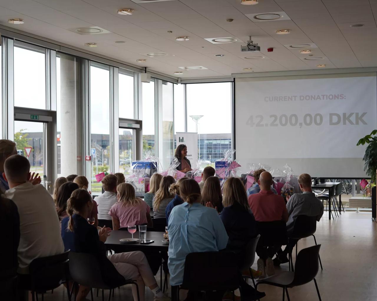 Whiteaways medarbejdere samlet for at høre det samlede beløb til Lyserød Lørdag 