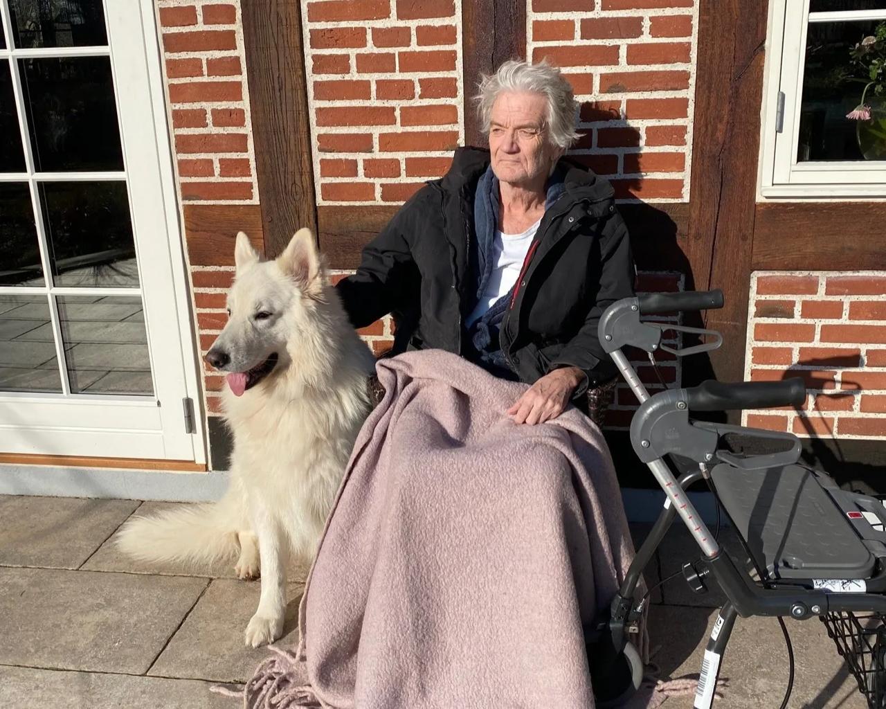 Lars fotograferet et par dage efter hjemkomst fra hospitalet. Familiens hund Bifrost passer på ham og det nye gangstativ.