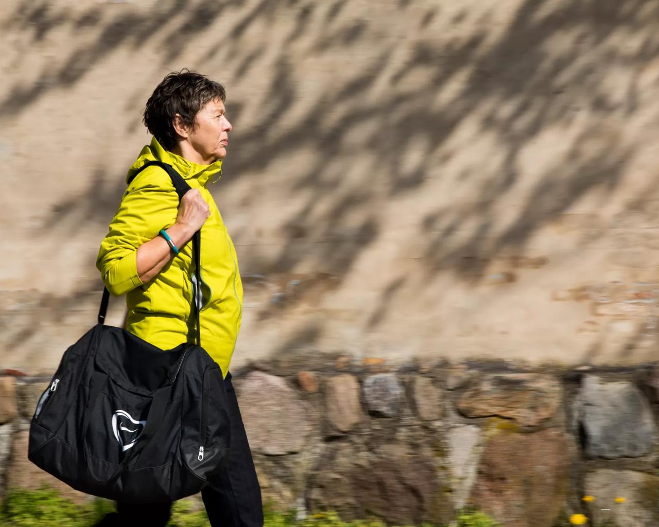 Kvinde i gult går langs muren