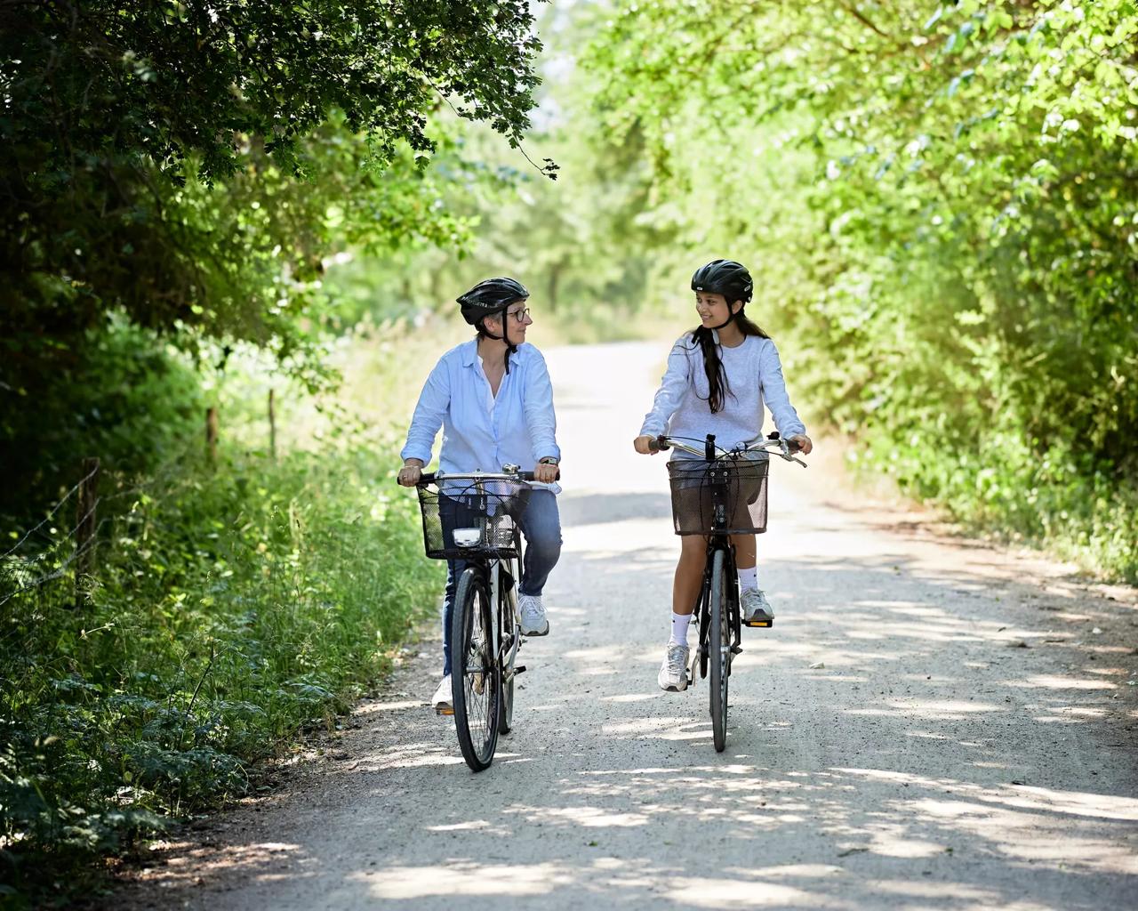 Kvinde og pige, der er fysisk aktive og cykler