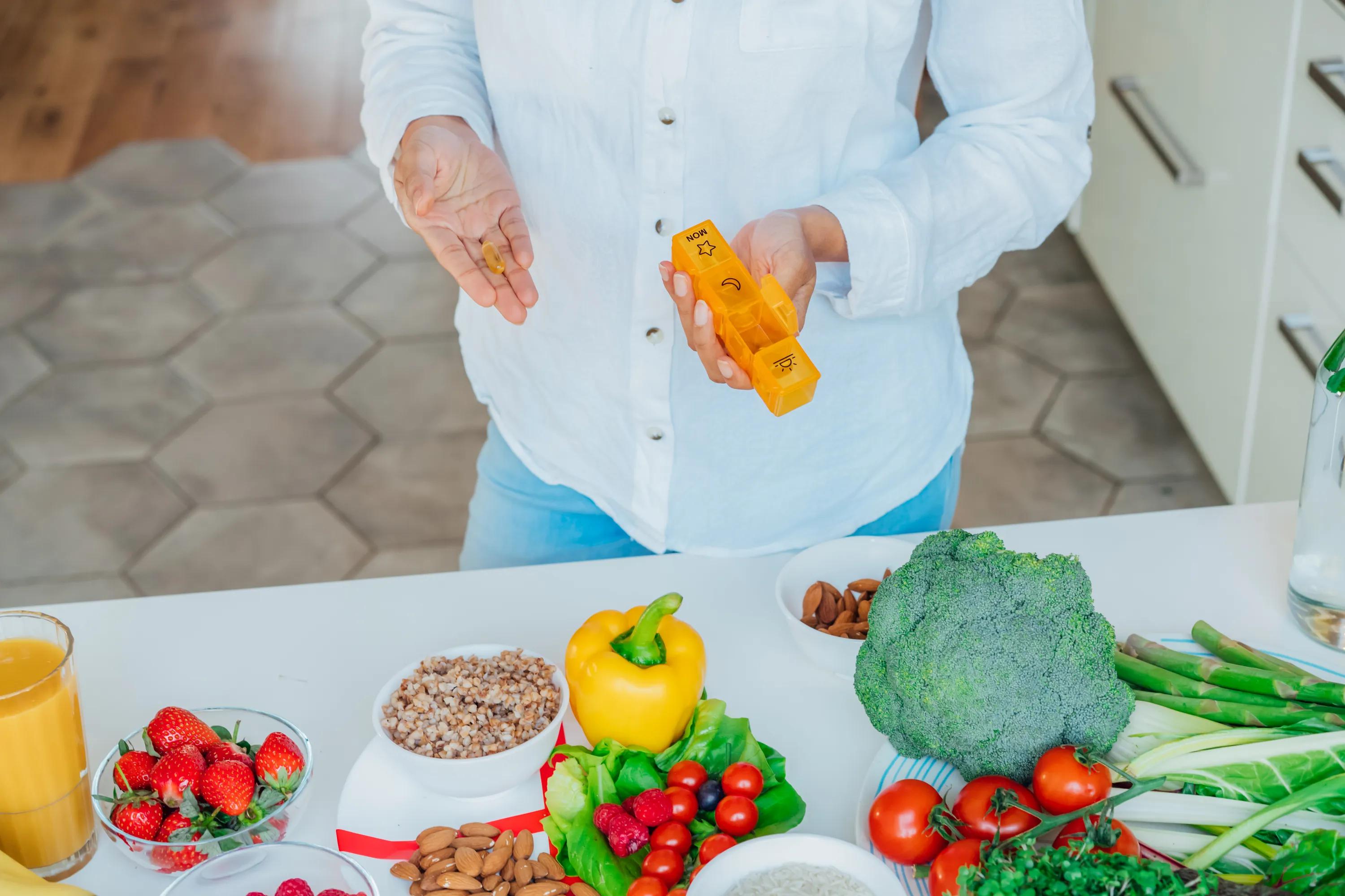 Kvinde holder pille og pilleæske i hænderne