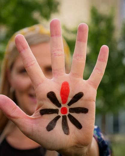 Kvinde sætter en lyspose til lysceremonien
