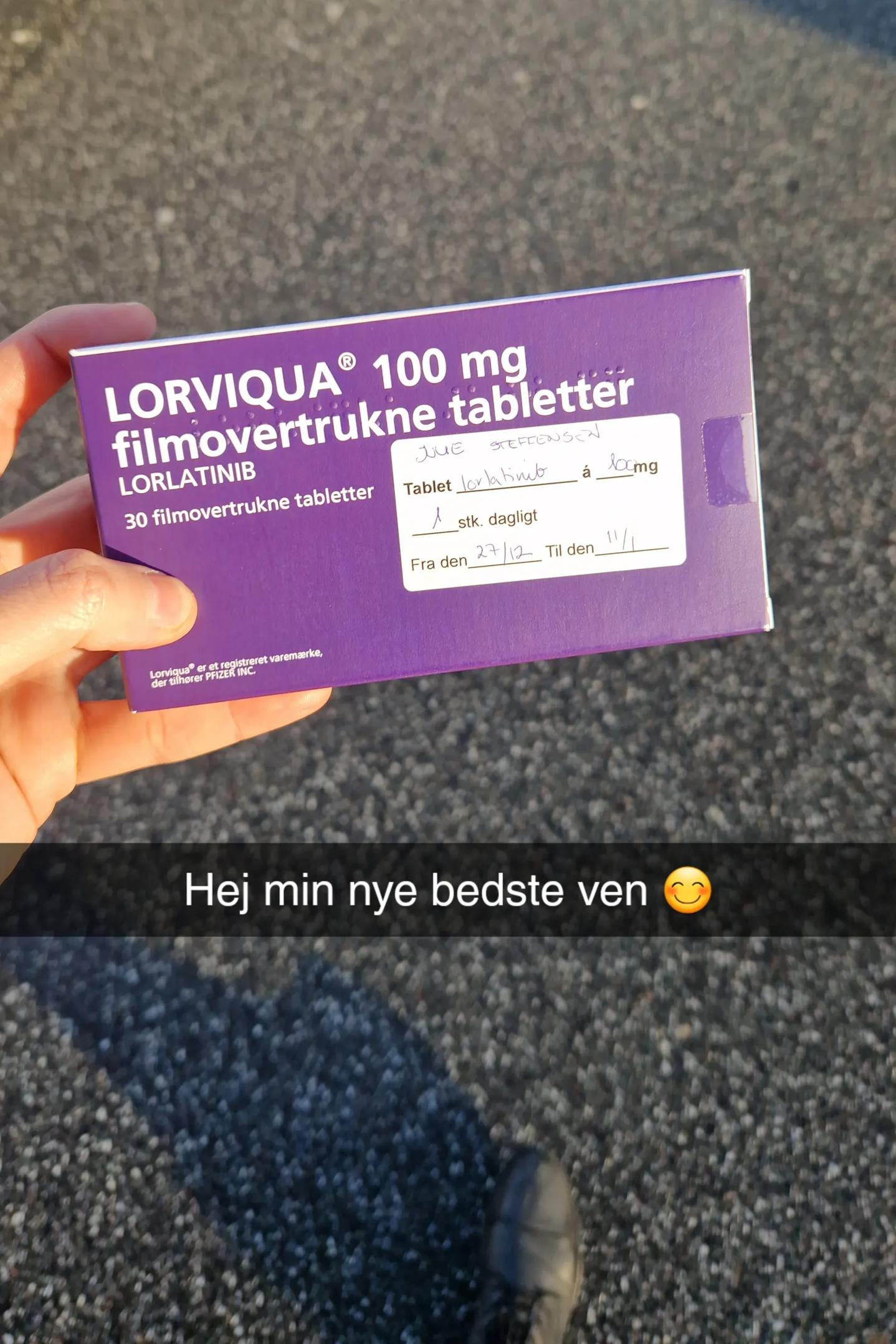 Julie holder æske med medicin i hånden.