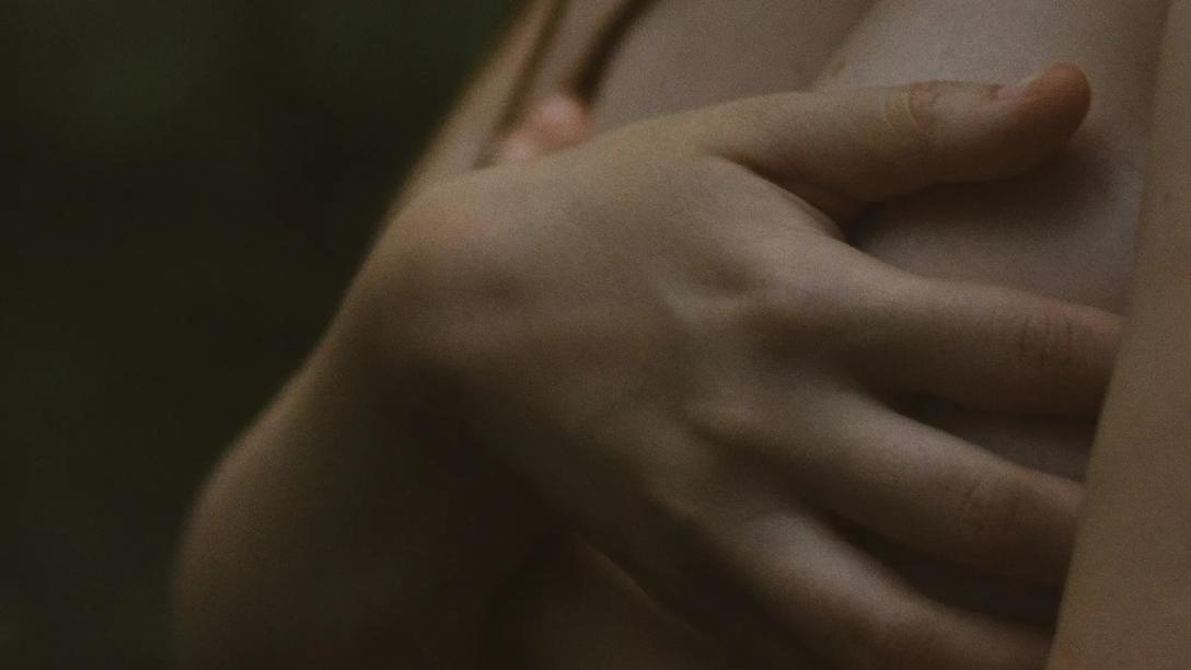 Foto af kvinde, der holder hænderne foran sit bryst