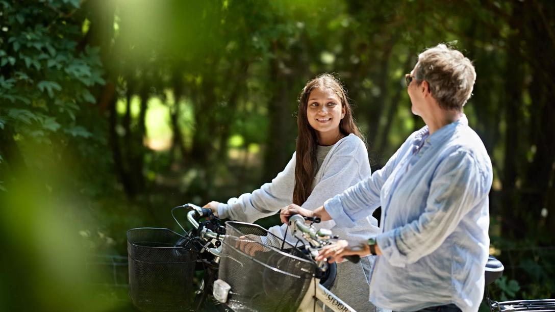 Pige og kvinde cykler i skoven