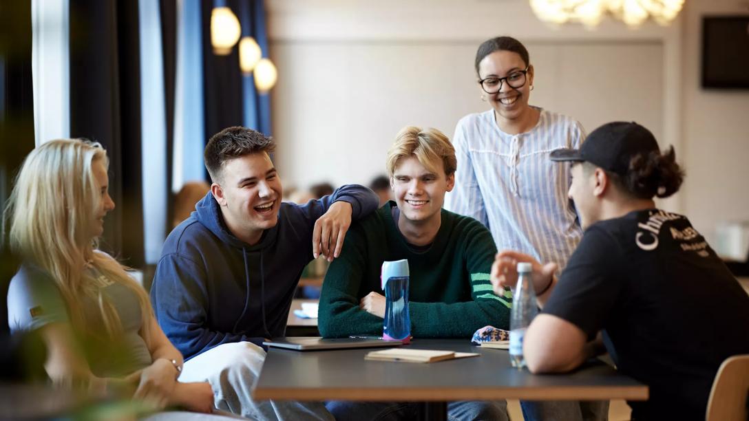 Unge gymnasieelever, der taler sammen.