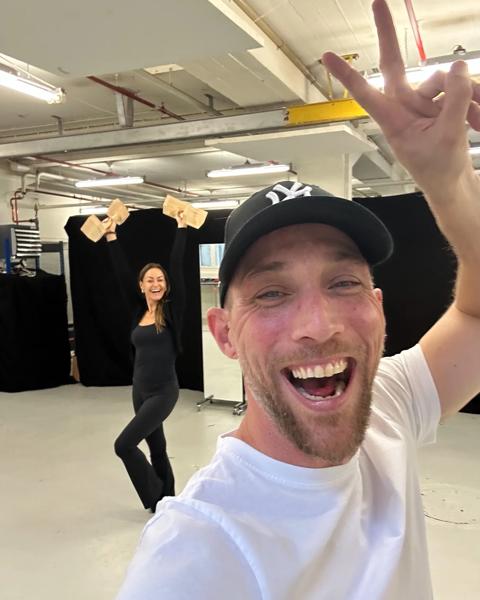 Emil smil med dansepartneren i vild med dans i baggrunden.