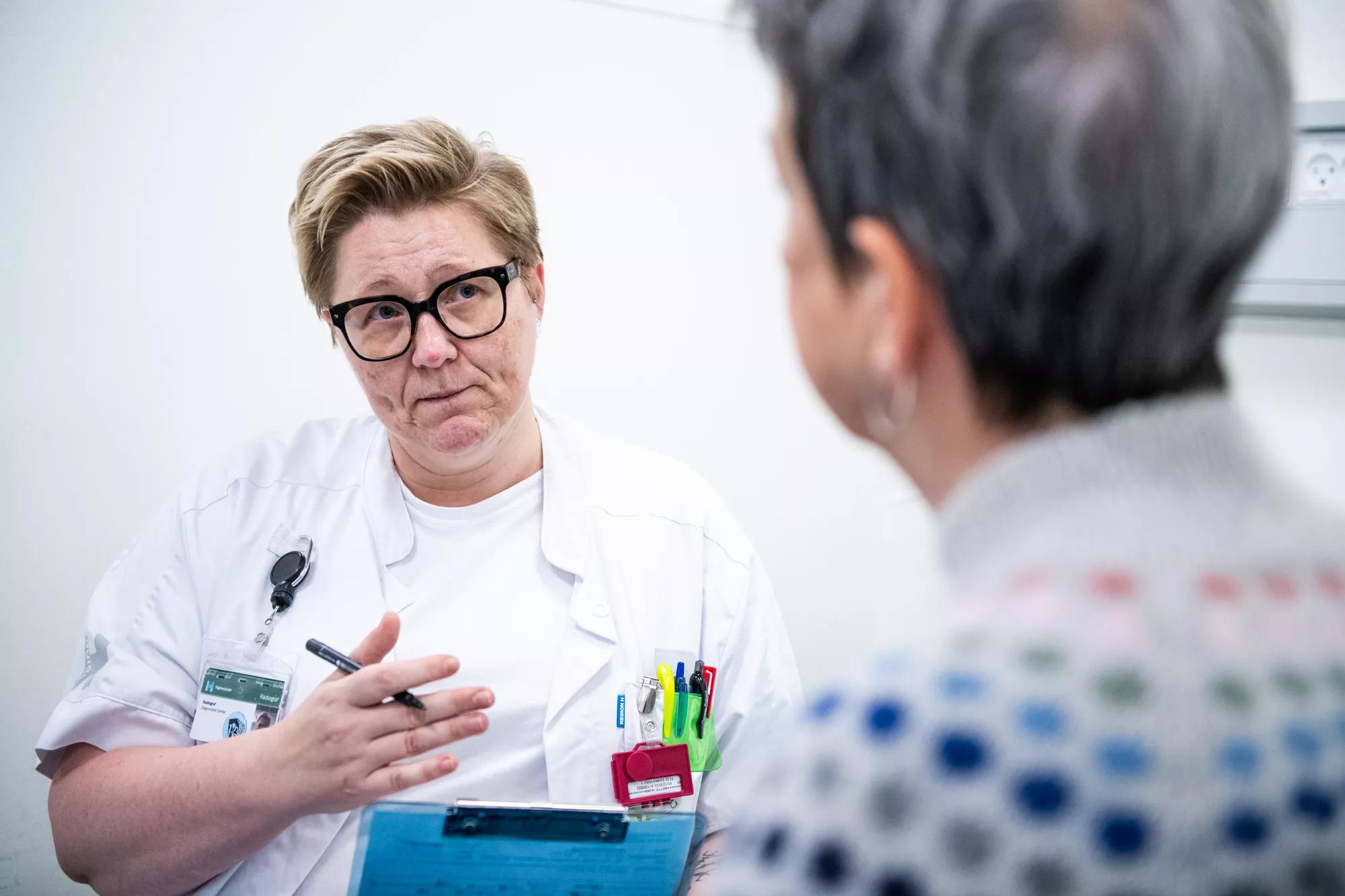 Sygeplejerske taler med patient