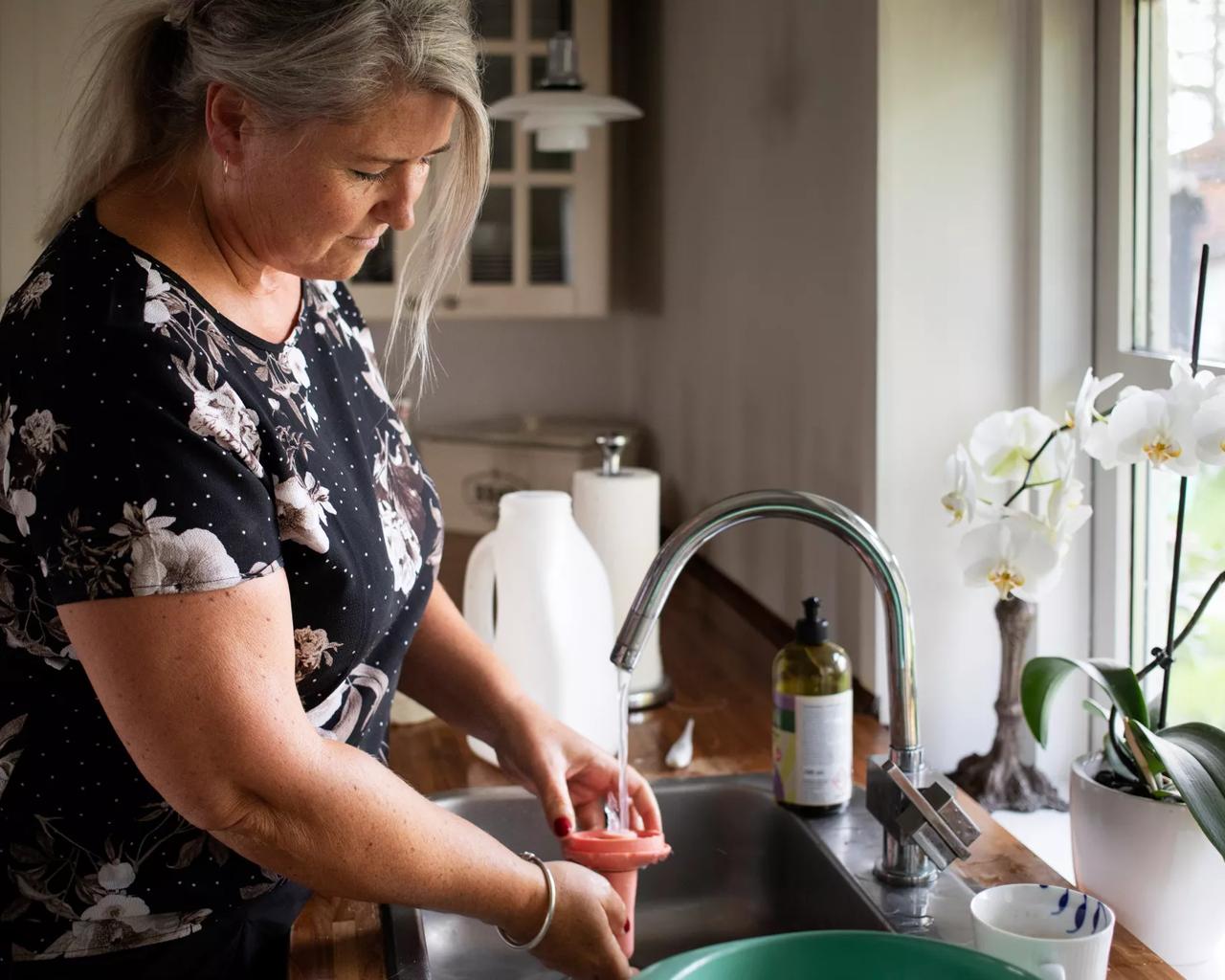 Kvinde vasker op ved vindue