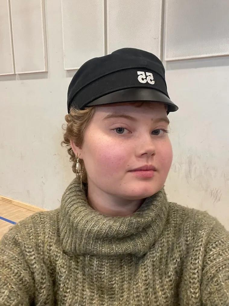 Marie står med en sort studenterhue på hovedet