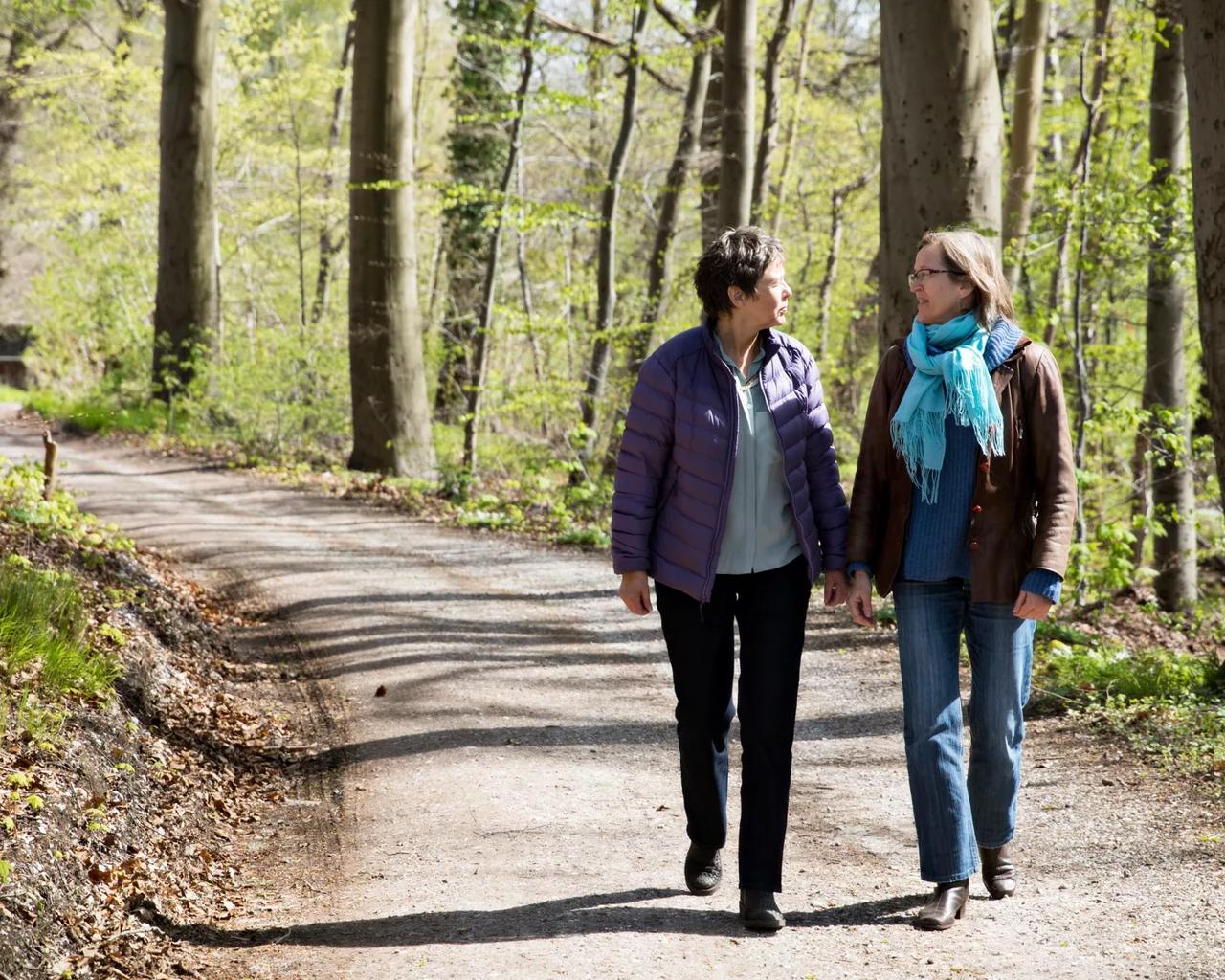 To kvinder går tur i skoven og snakker sammen