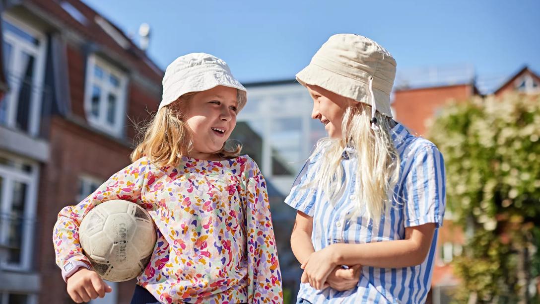 Børn står i solen, men beskytter sig mod uv-stråling