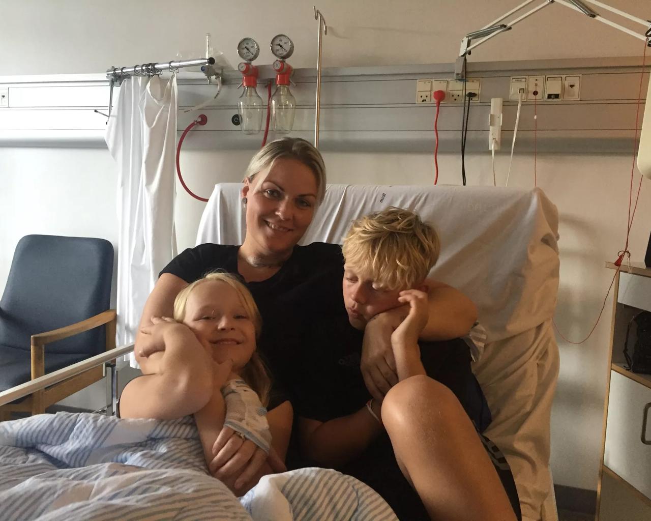 Julie med sine børn Xenia og Marcus i hospitalssengen. Det er vigtigt for Julie, at børnene mærker så lidt til at hun har senfølger, som muligt. Privatfoto.