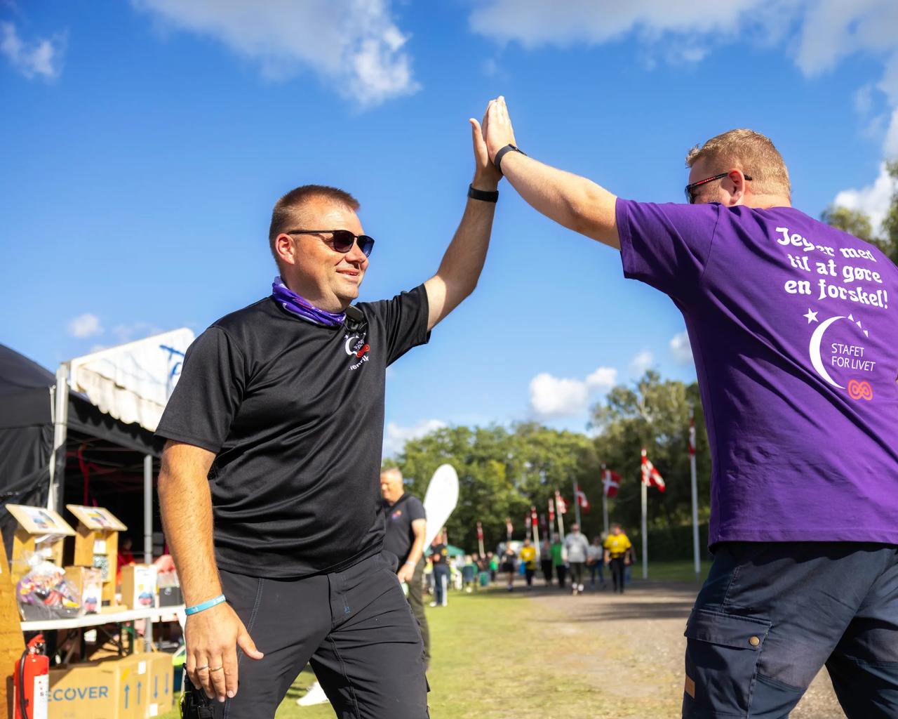 To mænd giver high fives ved Stafet For Livet