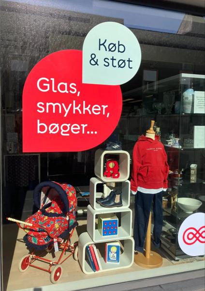 Butiksvindue dekoreret i farverne blå, beige og hvid