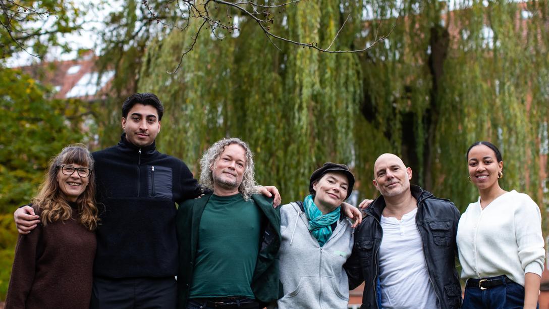 en gruppe mennesker i forskellige aldre og køn, holder om hinanden for at udvise sammenhold