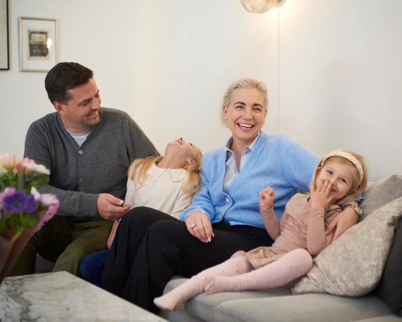 Karen sidder med familien i sofaen og griner