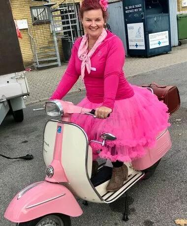 Henriette på en lyserød scooter