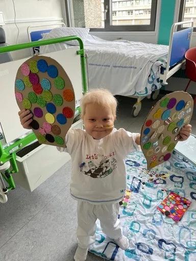 Smilende Hugo holder legetøj på hospitalet 