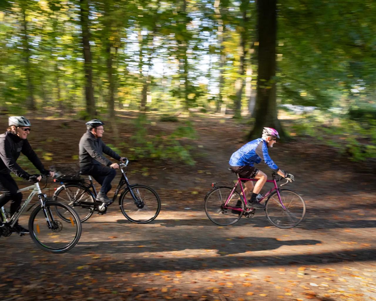 Tre modne mænd, der cykler på mountainbike