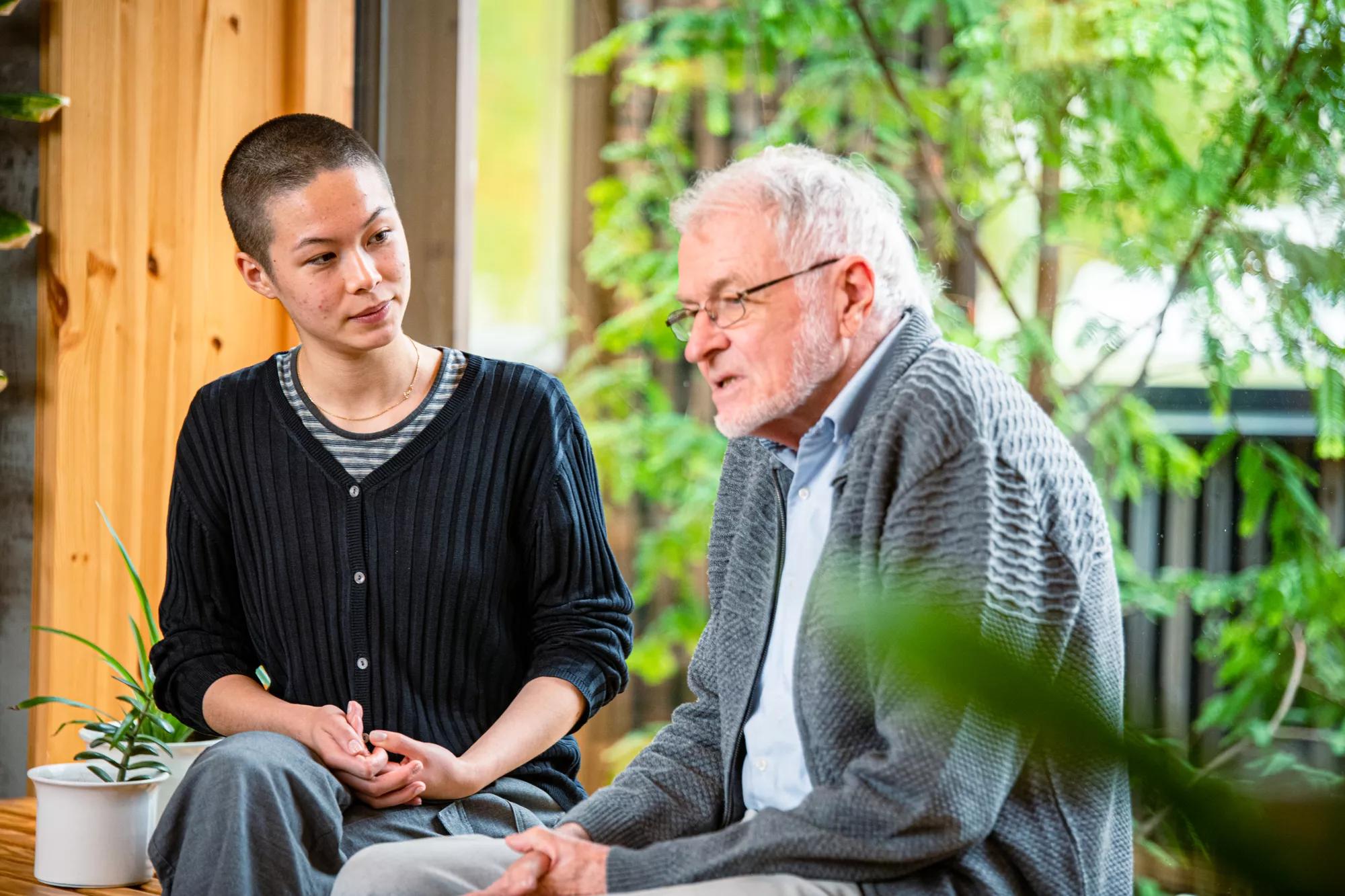 En mand og en kvinde sidder og taler ved et vindue | Kræftrådgivningen Herlev