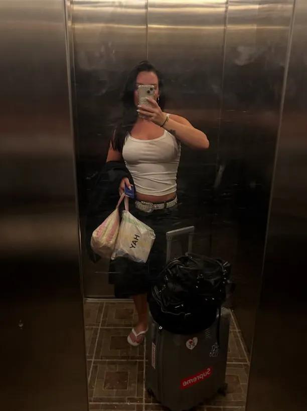 Cecilie står med kuffert i elevator 