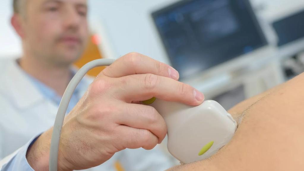 Læge holder ultralydsscanner på patients mave