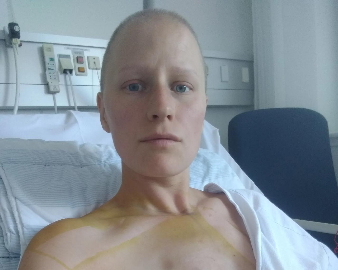 Lisa ligger i hospitalsseng med forbinding om sit ene bryst. 