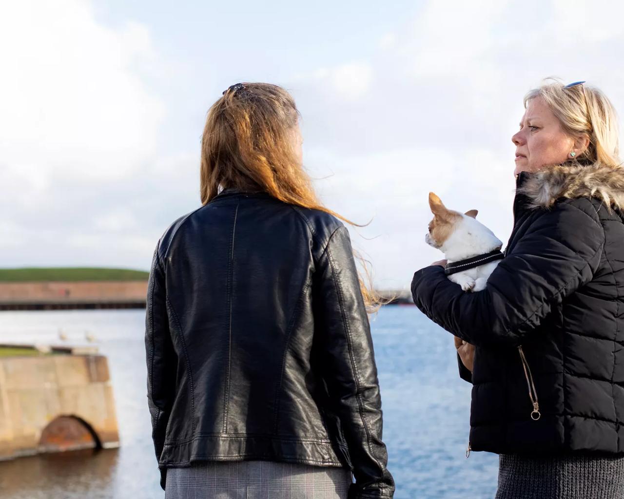 To kvinder står og taler sammen ved havnefront