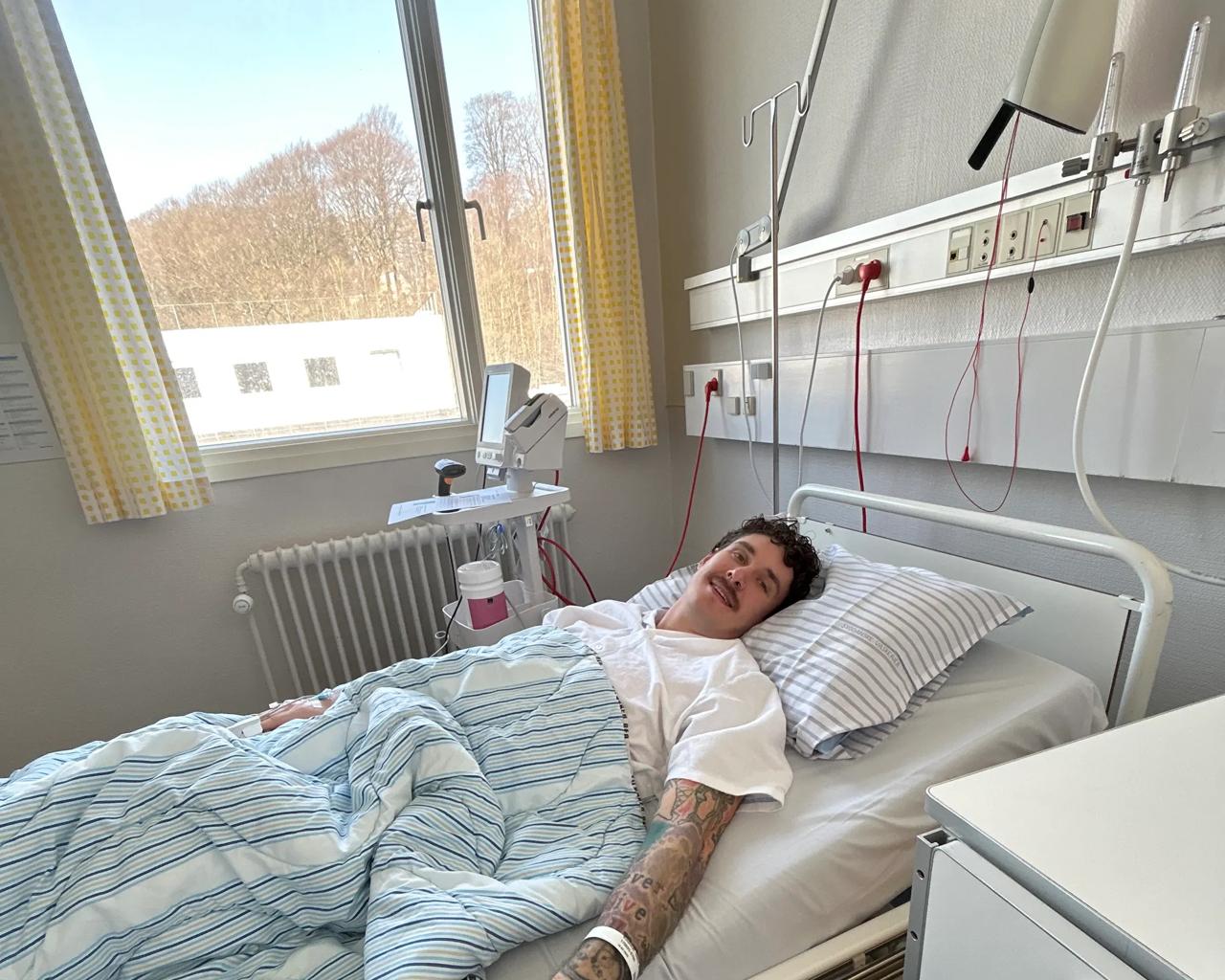 Glenn ligger i en hospitalsseng og holder Cecilie i hånden.