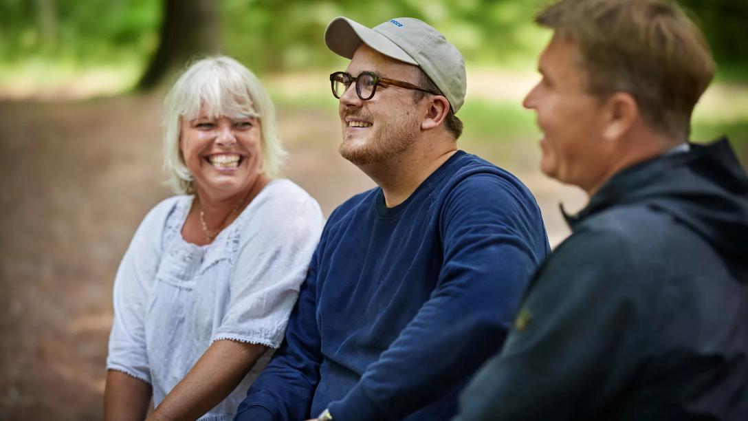 Overvægtig person sidder i skoven med sine venner