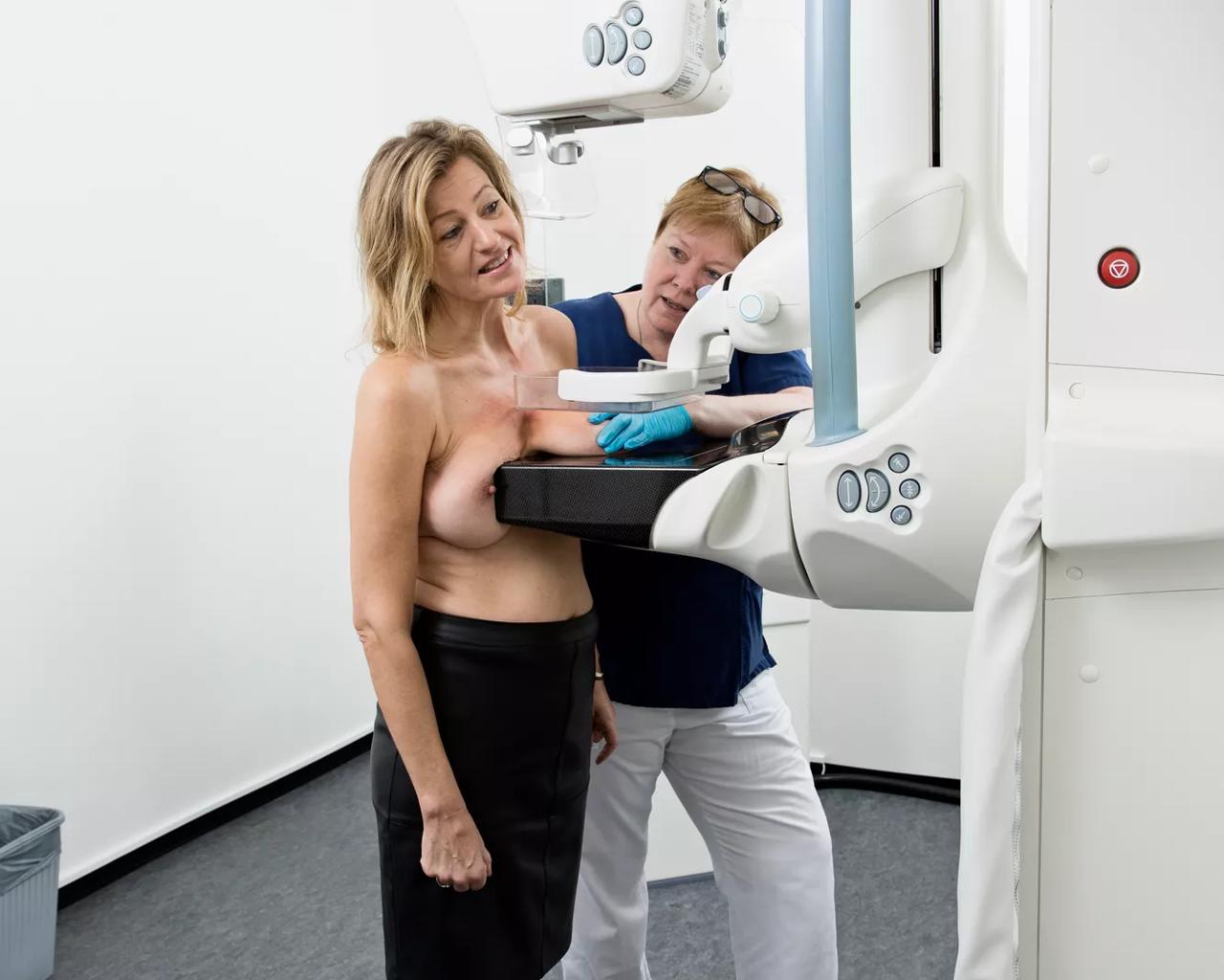 Billedet viser en kvinde, der får foretaget en mammografi