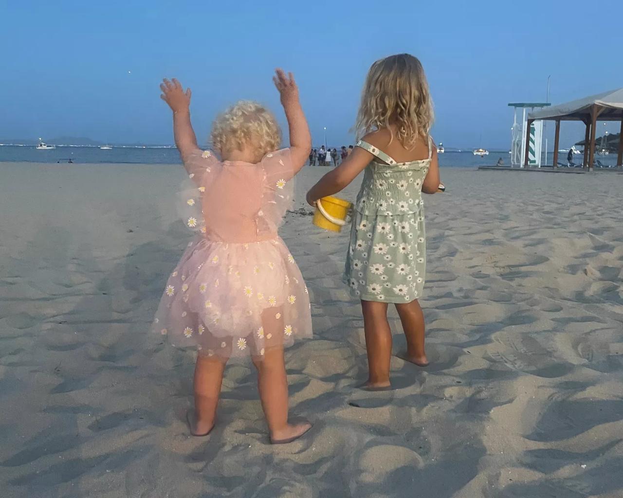 Hollie og storesøster leger på stranden