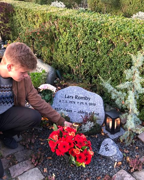 Magne og Asger lægger blomster ved deres fars gravsten 